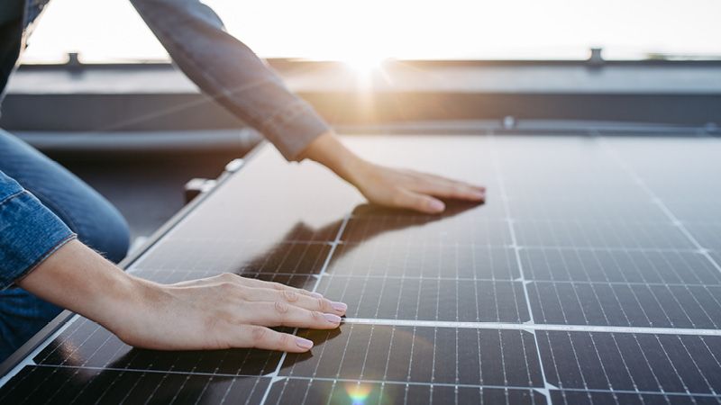 Hände auf Solarmodulen